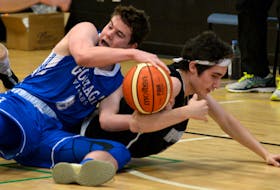 Gonzaga’s Andrew Shears (left) and Holy Heart’s Alex Sparrow fight for the ball during the male Tier 1 final in the Keith Keating Memorial basketball tournament Sunday at Waterford Valley High. Sparrow was named tourney MVP after helping the Highlanders to a 100-70 win over the Vikings.