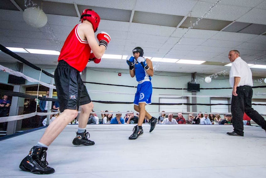 Submitted photo/Arthur Inox — Nick Callahan (left) of the TRC Boxing Club and Muhammad Mansour of Mike Foley’s Academy of Martial Arts square off under the watchful eye of referee Kevin Greeley (right) during TRC’s annual boxing/dinner show at the Pleasantville Legion in St. John’s on Friday night. Mansour won in a split decision.