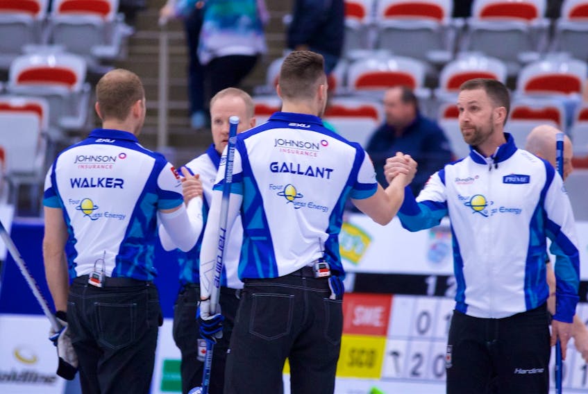 Anil Mungal/World Curling Tour — Members of the Team Gushue curling rink, from left Geoff Walker, Mark Nichols, Brett Gallant and Brad Gushue, clasp hands after winning the Humpty’s Champions Cup in Calgary Sunday.