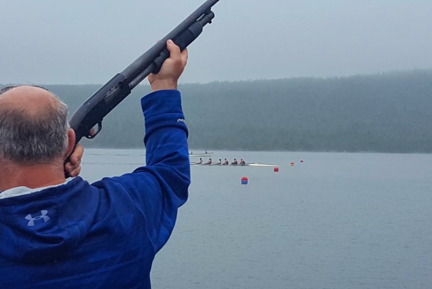 The start/finish line marshal prepares to fire the gun as the Telegram United Home Hardware crew crosses the finish line in first place in the third senior women’s race of the day at the 156th Harbour Grace Regatta at Lady Lake Saturday. — Submitted photo/Meleny Yetman