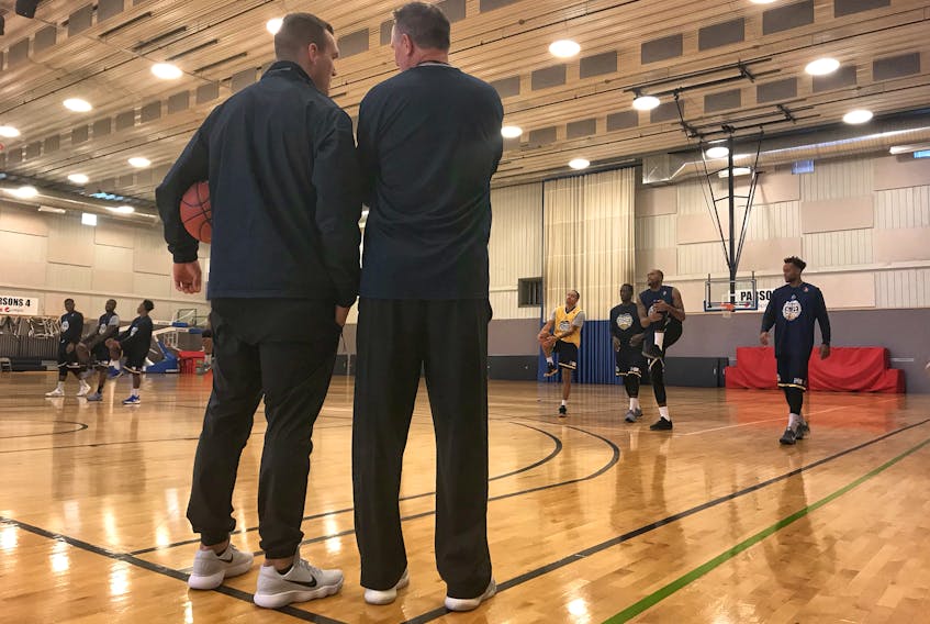 St. John's Edge photo — St. John’s Edge head coach Jeff Dunlap (right) and assistant coach Doug Plumb talk as players go through drills at the Newfoundland Training Centre in St. John’s on Wednesday. The National Basketball League of Canada expansion team had been holding unofficial workouts at the facility since Monday, but Wednesday marked the official start of training camp. The Edge play their first regular-season contest Nov. 18 and their first home game on Dec. 1.