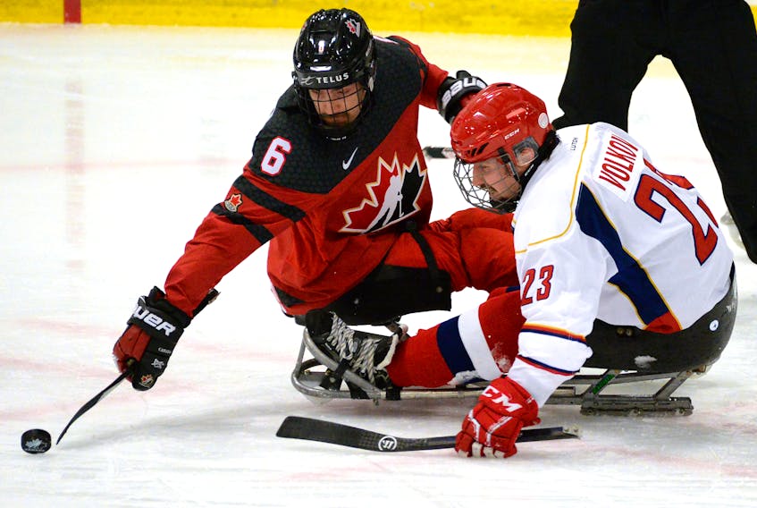 Canada’s Rob Armstrong (left) and Russia’s Ilia Volkov fight for the puck during their game Monday night at the 2019 Canadian Tire Para Hockey Cup at the Paradise Double Ice Complex. Russia went on to beat Canada 3-2 in a game decided by a shootout. — Keith Gosse/The Telegram