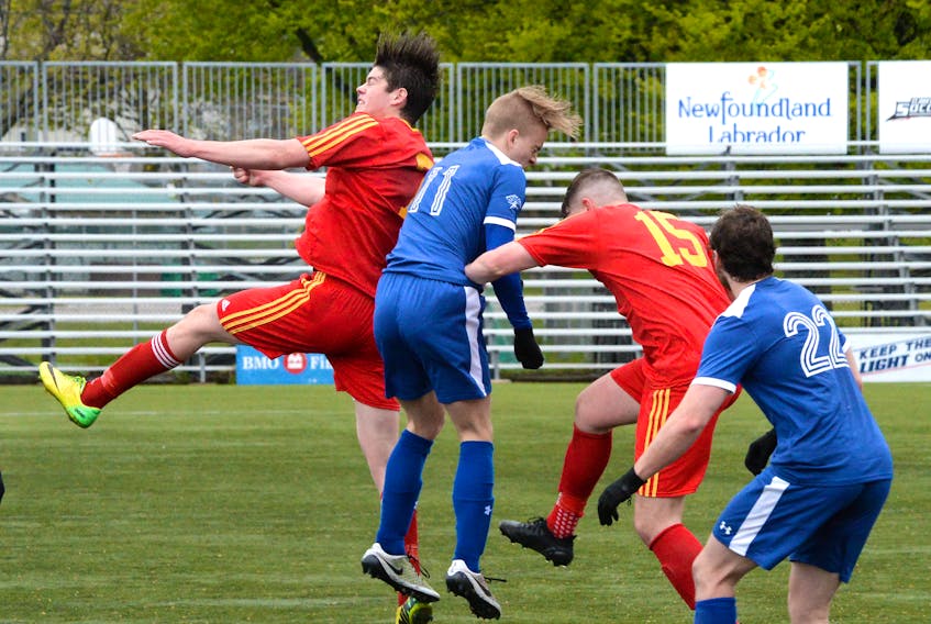 Holy Cross players (in red) and Paradise opponents go airborne for the ball during Challenge Cup provincial senior men’s soccer play Saturday at King George V Park in St. John’s. Holy Cross won 1-0.