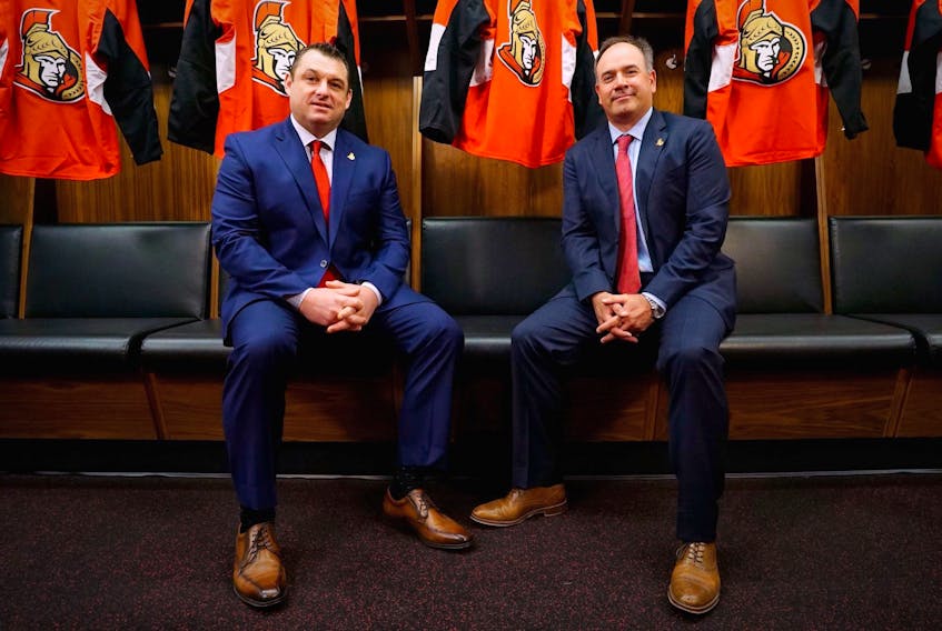 New Ottawa Senators head coach D. J. Smith (left) and general manager Pierre Doiron pose in the Senators’ dressing room after Smith’s hiring was announced Thursday in Ottawa. — Ottawa Senators photo via Twitter