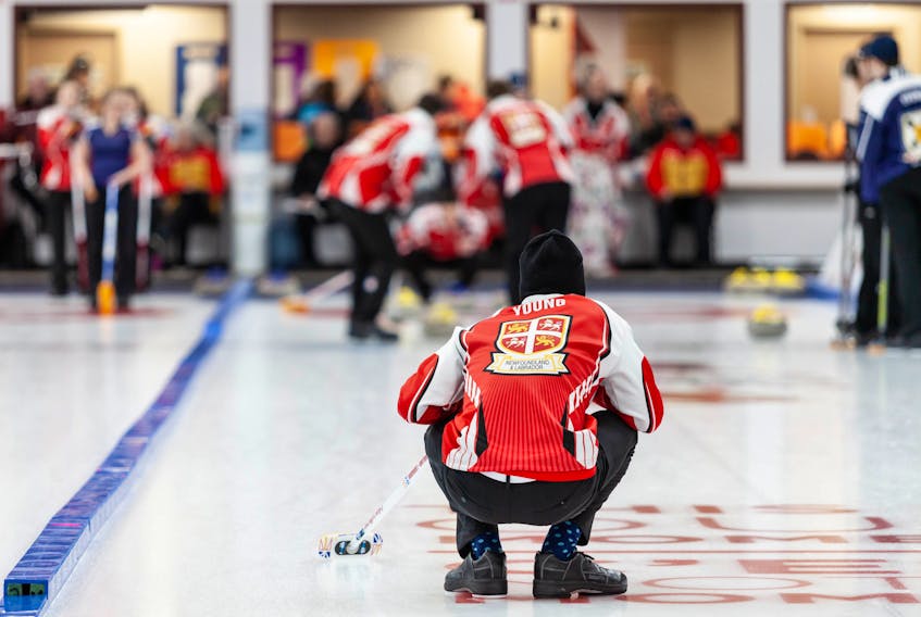 Canada Games photo/Kelly Tarala - Newfoundland and Labrador skip Nathan Young looks down the sheet as his front end sweeps a rock into the house during curling competition at the 2019 Canada Winter Games in Red Deer, Alta.