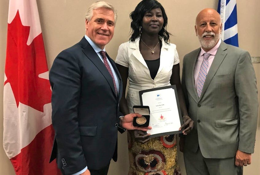 Premier Dwight Ball (left) stands with St. John’s resident Suna Dau Yath, Council of the Federation Literacy Award winner, and Al Hawkins, minister of Advanced Education, Skills and Labour.