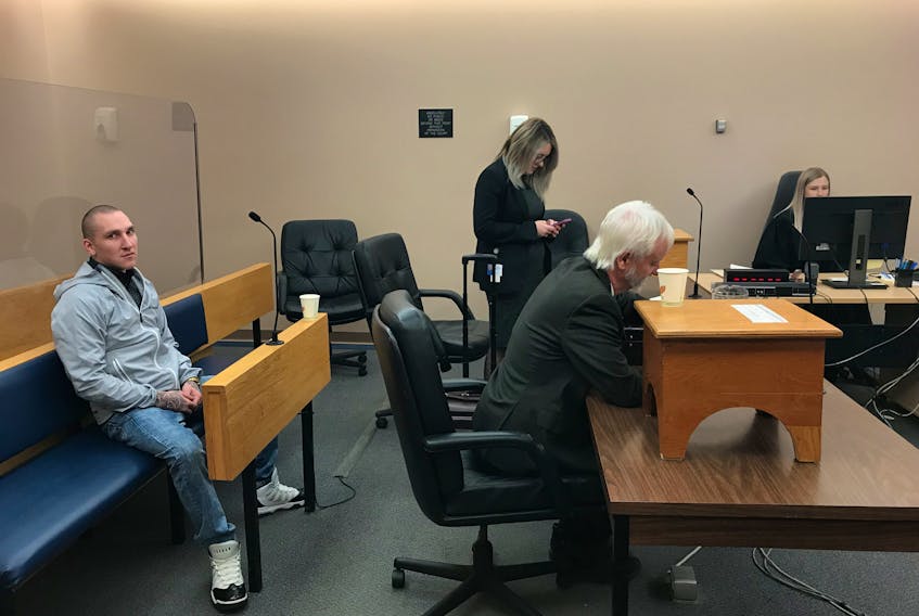 Corey Michael Evans sits in a provincial courtroom in St. John’s Friday morning, shortly after he was acquitted of charges related to a stabbing on George Street in September of last year. In front of him are his defence lawyer, Randy Piercey, and Crown prosecutor Erin Matthews.