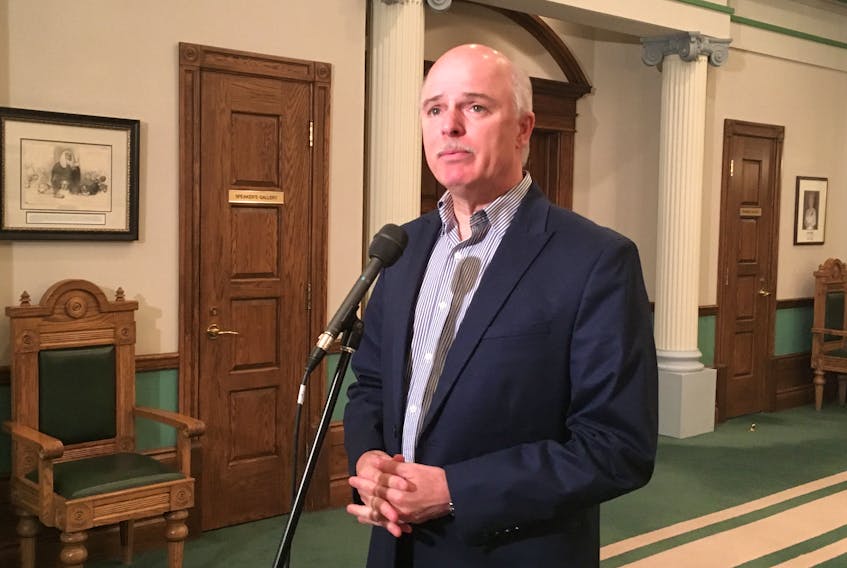 Pleased to have a tentative agreement with CUPE, Finance Minister Tom Osborne takes questions from reporters in front of the House of Assembly at Confederation Building Thursday.