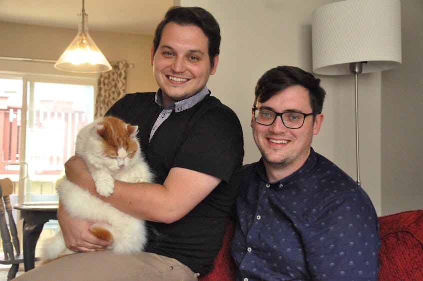 Josh Eddy (left) and Colin Williams (right), shown here with their eight-year-old cat, Henry, are the owners of the Mad Catter Café, Newfoundland’s first cat café in downtown St. John’s. - Kenn Oliver