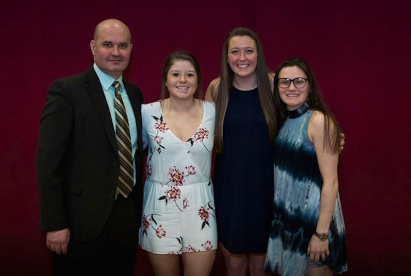 Norwich University Athletics — Norwich University defenceman Robyn Foley (second from the left) poses with head coach Mark Bolding (left) and teammates Kimi Tiberi and Amanda Conway (right) after the three players were named AHCA East Region All-Americans during the 2018 NCAA Division III Women's Ice Hockey Championship banquet in Northfield, Vt. Foley, a third-year player from Goulds, helped Norwich to a Division III national championship with a whopping plus-55 rating.