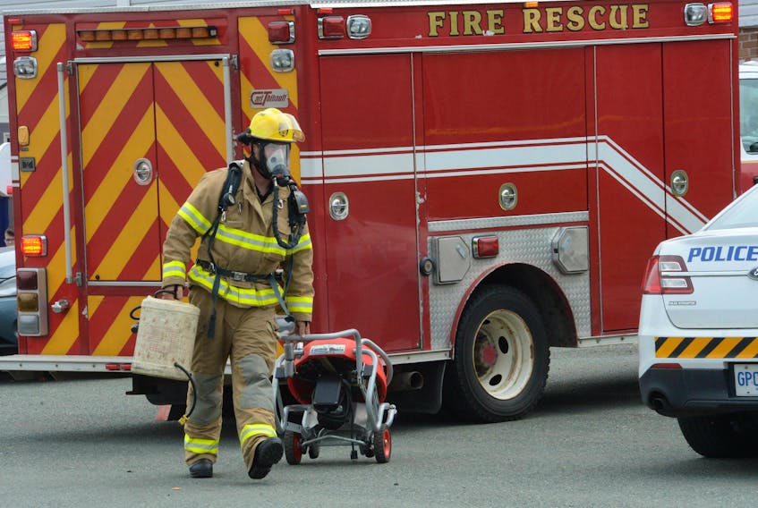 A St. John's firefighter takes his equipment to the scene of a fire in a recent file photo.