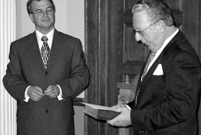 Lloyd L.W. Wicks (right) takes the oath of office to become the province's first Child and Youth Advocate - September 16, 2002. At left is John Noel, Clerk of the House of Assembly. — Handout photo/Provincial Government archive