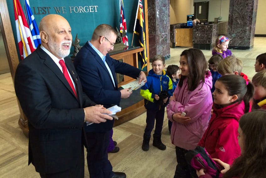 Students from Bishop Feild Elementary School in St. John's hand delivered letters to Al Hawkins (left), minister of education and early childhood development, and Steve Crocker, the province's minister of transportation and works at Confederation Building Monday morning. The students have been displaced from their school for 15 months.