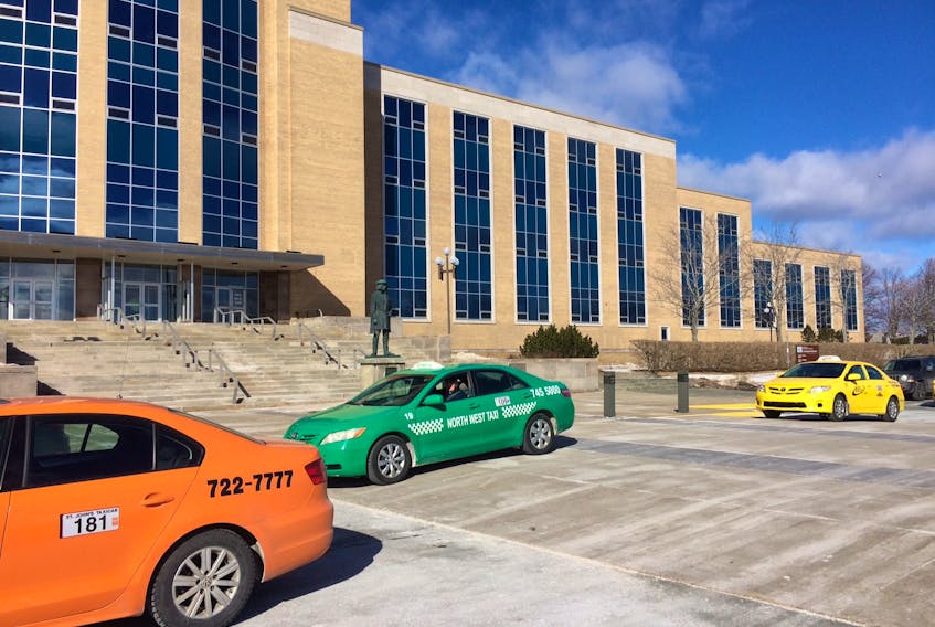 Cab drivers make a taxi train around Confederation Building in St. John's Friday morning.