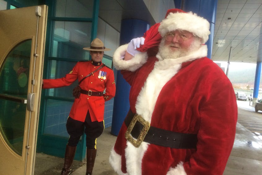 Santa arrives at the Janeway to bring his bag of goodies to share with children there Saturday just before noon. He had a fine contingent of helpers: the Royal Canadian Mounted Police dressed in their finest to escort him on his way to the 34th Annual RCMP/Janeway Children's Christmas Party. Holding the door is Sgt. Dave Hains. — Deb Squires/The Telegram