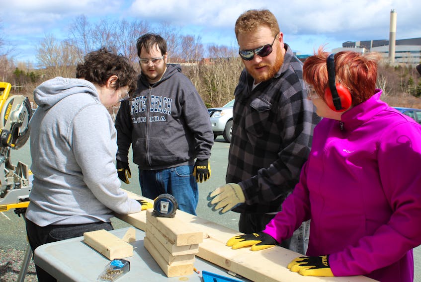 Participants have been working hard recently to put together planting beds that the Autism Society of Newfoundland and Labrador will be selling to the public. Working on one of the projects is (from left) Gordon Drover, Riley Petite and Hayley Moore all under the watchful eye of Jeff Ronan, project co-ordinator for ASNL.