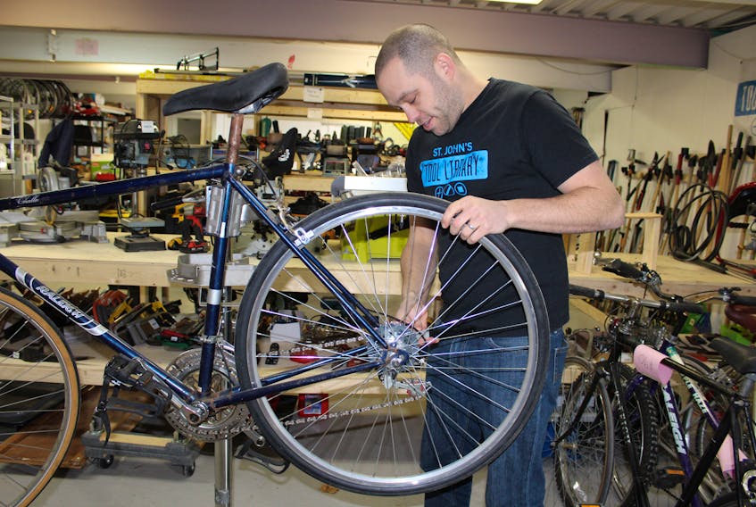 Ian Froude, founder and executive director of the St. John's Tool Library, works on a bike at his new Empire Avenue shop that will help people with a variety of do-it-yourself projects.