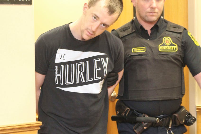Thomas Keeping is escorted out of provincial court by a sheriff’s officer Wednesday.