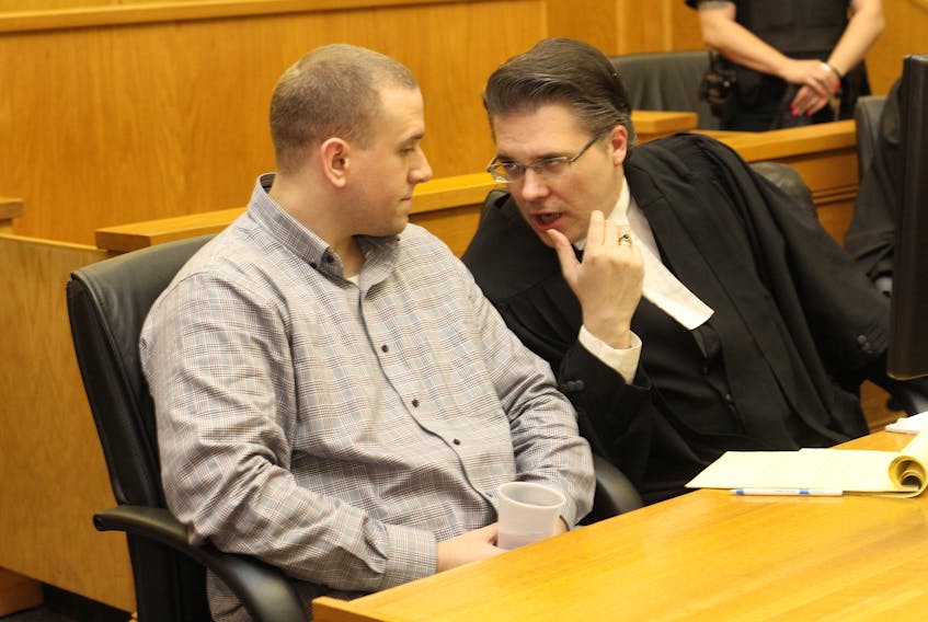 Brandon Phillips (left) speaks with Mark Gruchy, one of his lawyers, during the first day of testimony in his murder trial at Newfoundland and Labrador Supreme Court Thursday afternoon.