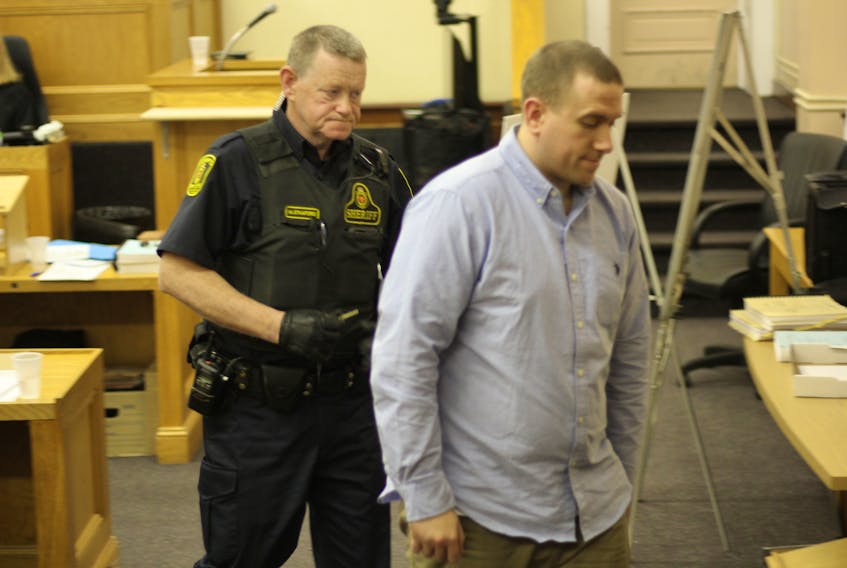Accused murdered Brandon Phillips, 29, is escorted by a sheriff’s officer back to the lockup after his trial wrapped up for the day Wednesday.