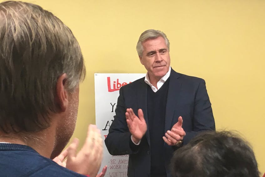 Premier Dwight Ball joins supporters in a round of applause Tuesday night at Liberal candidate Jim Burton’s campaign headquarters.