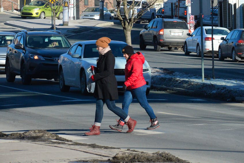 Pedestrians make their way across the crosswalk on New Gower Street in front of St. John’s City Hall in downtown St. John’s on Friday afternoon. After a year that saw three pedestrian fatalities in the Northeast Avalon, the RNC is stressing the importance of pedestrians and drivers following the rules of the road, especially this time of year.