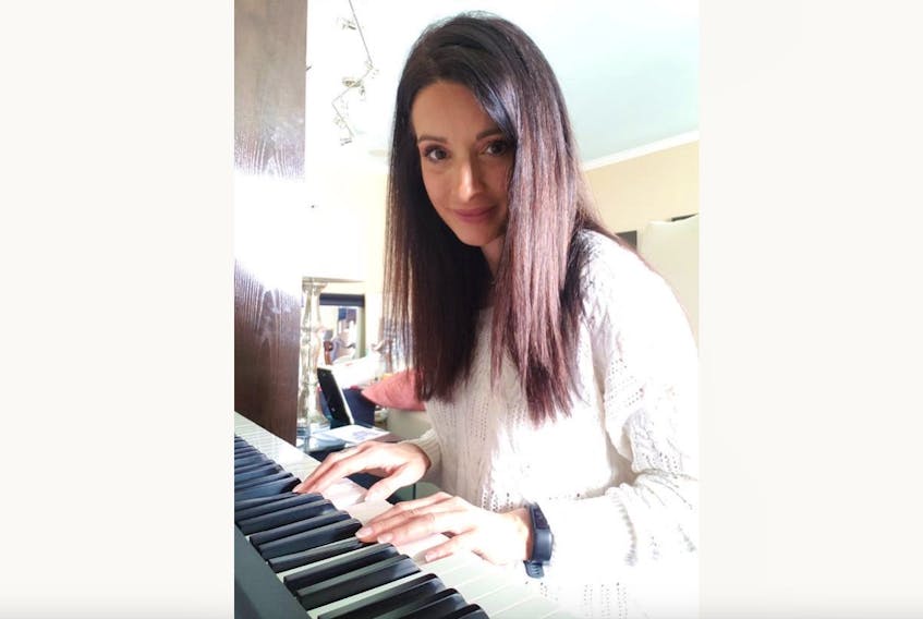 Gambo native April Goulding at the piano in her home in Laval, Que.