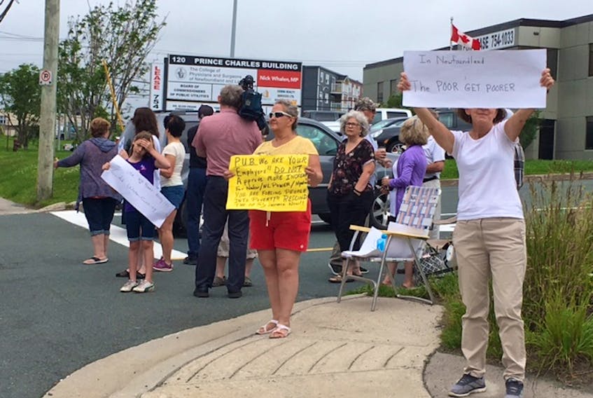 A handful of protesters outside the building that's home to the Public Utilities Board, on Torbay Road in St. John’s this morning. — Glen Whiffen/The Telegram