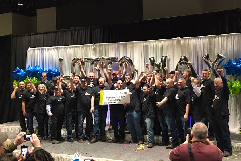 A group of employees of the Come By Chance oil refinery are radiant as they accept their cheque for $60 million from the Atlantic Lottery Corp. in St. John’s, Feb. 28. — Sam McNeish/The Telegram