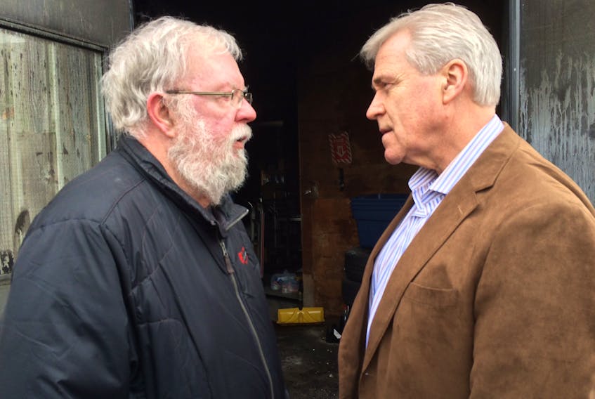 Community Food Sharing Association executive director Eg Walters (left) chats with Premier Dwight Ball outside the CFSA’s warehouse on Topsail Road, where fire ripped through the facility that housed the food supply for many community food banks. Before leaving, Ball was heard telling Walters, “A nice new food bank will rise from the ashes." — Photo by Joe Gibbons/The Telegram