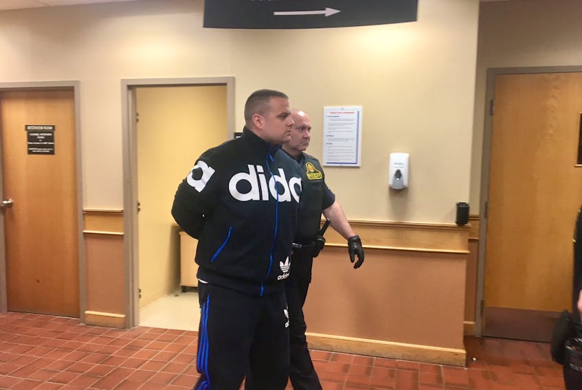 Steven Neville is led out of provincial court in St. John’s Wednesday, two days after he was arrested on charges of assaulting a woman and sending intimate images of her on two occasions, as well as breaching court orders. He’s due back in court Thursday for a bail hearing.