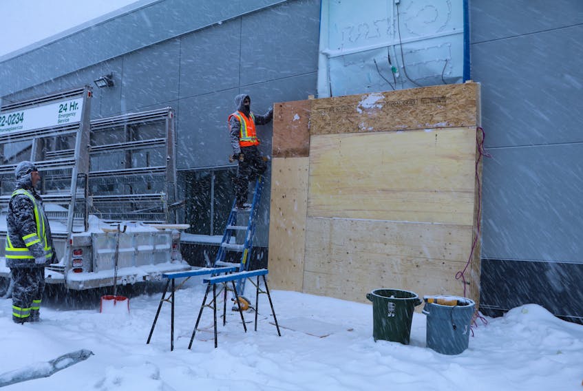 Workers from Thomas Glass put a temporary seal over a huge hole Saturday morning in the side of the Bank of Montreal (BMO) on Newfoundland Drive in St. John’s. The exterior wall containing the bank’s drive-thru ATM was ripped open.