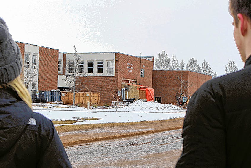 Two students stand outside Three Oaks Senior High School which is undergoing major renovations.  ©THE GUARDIAN