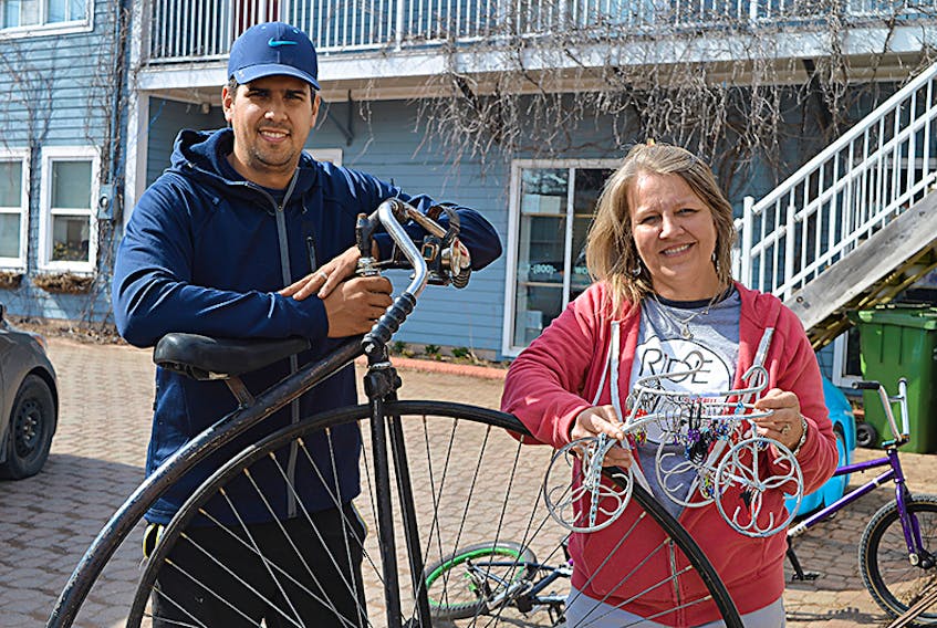 MacQueen’s Bike Shop is one of the businesses that has been certified as sustainable by the City of Charlottetown. Store employee Dayan Gonzalez holds one of the more unique products available, the penny-farthing bike, while Kristen MacQueen holds a piece of artwork that has been made out of recycled bike parts.  ©THE GUARDIAN