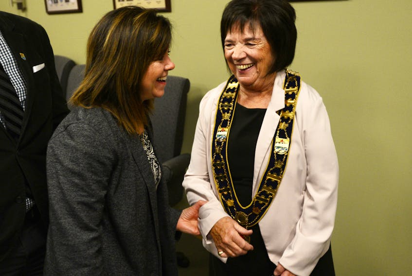 Cornwall mayor Minerva McCourt is congratulated by her sister, Elizabeth MacDonald, during the swearing-in ceremony held at Cornwall Town Hall on Tuesday. In the photo at right, Coun. Cory Stevenson and Coun. Corey Frizzell congratulate each other during the ceremony. Stevenson has also been named as the town’s deputy mayor.