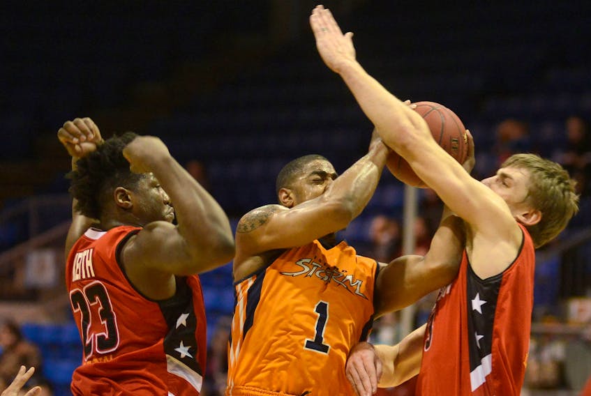Island Storm forward Chris Johnson, centre, is fouled by Windsor Express forward Shaquille Keith, left, after driving on Logan Stutz Saturday during National Basketball League of Canada action at the Eastlink Centre.