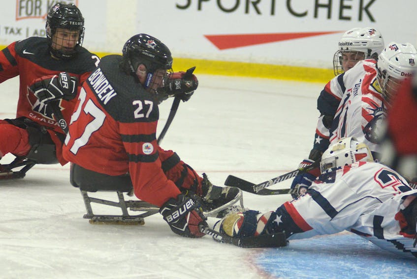 USA goalie Steve Cash covers a loose puck before Canada’s Brad Bowden can get to it during Wednesday’s World Sledge Hockey Challenge at MacLauchlan Arena.