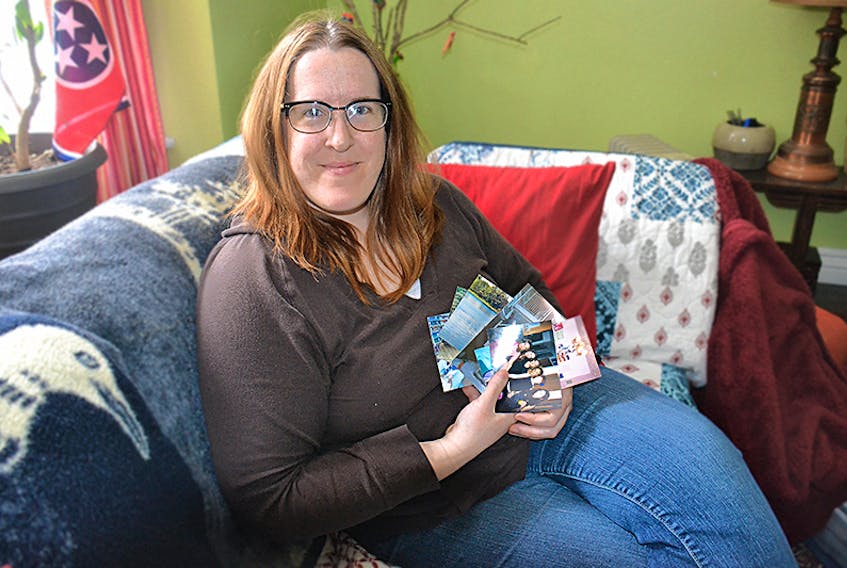 Andrea MacDonald, shown at her home in Charlottetown, looks over photos of her time spent in the Katimavik program.  ©THE GUARDIAN