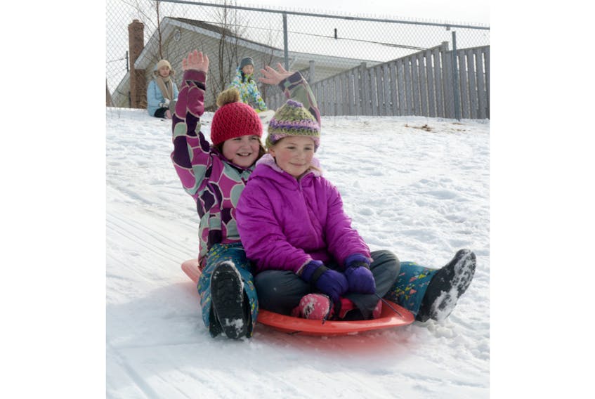 Lyneah Savard, left, celebrates her birthday with friend Lily Gates while sledding at Stonepark Intermediate on the weekend. Savard, who turns nine on March 15, wanted to go sledding for her birthday party on Saturday. Luckily, snowfall on Thursday and Friday covered the hill in powder for the weekend.