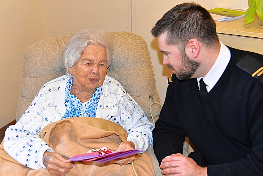 HMCS Queen Charlotte unit public affairs officer Spencer Lee delivers a Valentine’s Day card to 98-year-old Blanche MacAleer on Monday at the Mount Continuing Care Community residence as part of the Valentines for Vets initiative.  ©THE GUARDIAN