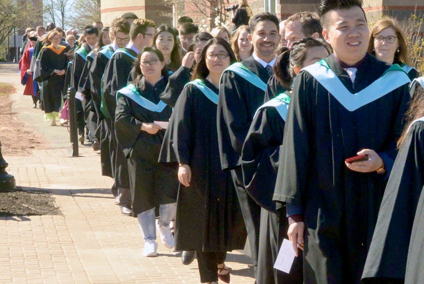 Graduates make the traditional trek across campus to the Chi-Wan Young Sports Centre for the 2017 morning convocation ceremony.