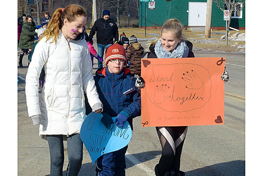 Georgetown Elementary School students, from left, Hannah Stoodley, Easter Seals ambassador Brayden White and Eden Boudreau, march down Kent Street during a silent walk for Family Violence Prevention Week in P.E.I. The week runs until Saturday, Feb. 17, and is supported by the Premier’s Action Committee on Family Violence Prevention.  ©THE GUARDIAN