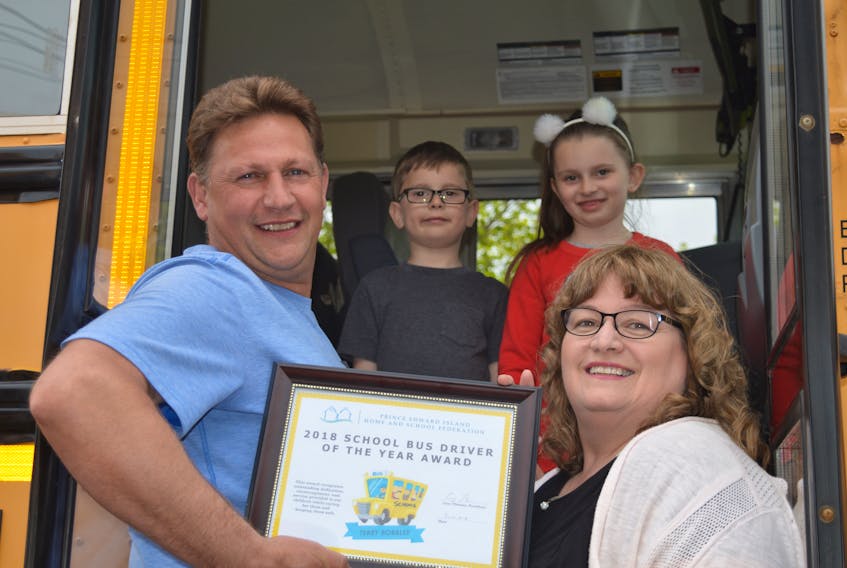 Donna MacLeod, bottom right, secretary of the P.E.I. Home and School Federation, presents Terry Robblee, who drives bus 169 to Englewood School in Crapaud, with the 2018 School Bus Driver of the Year Award. Also pictured are Englewood students Emmett McGeoghegan and Norah McGeoghegan. Robblee is one of a handful of bus drivers across the Island receiving the bus driver of the year recognition from the federation.
