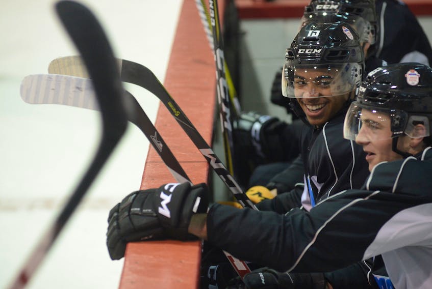 Pierre-Oliver Joseph, left, of the Charlottetown Islanders jokes with Summerside native Noah Dobson of the Acadie-Bathurst Titian on the Team QMJHL bench during practice on Monday in Charlottetown.