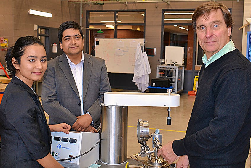International research student Ankita Shrestha, left, Bishnu Acharya, assistant professor at UPEI's School of Sustainable Design Engineering, and Mike Cassidy, owner of Transcon International Ltd., look over one of the machines used in their sea lettuce research at UPEI.  ©THE GUARDIAN