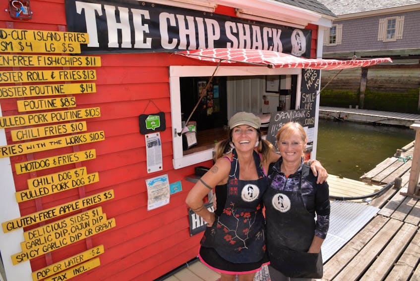 Caron Prins, aka Queen of the Fries, left, celebrates the opening of her Chip Shack at its new location with Dianne Pye.
