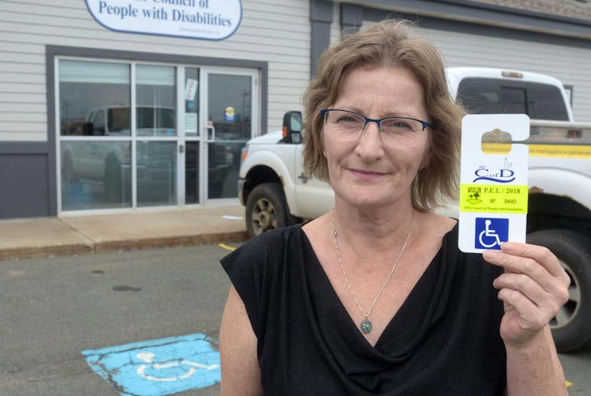 Kerry Duggan, community access worker for the P.E.I. Council of People with Disabilities, shows one of the province’s  designated parking permits.