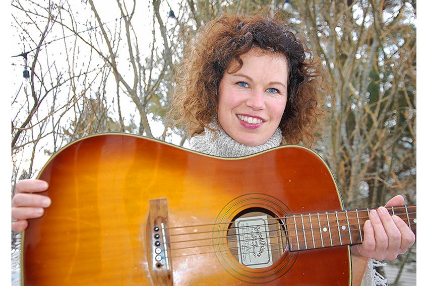 Singer/songwriter Jill Chandler of Stratford holds her first ever guitar - a gift from her parents when Chandler was in Grade 11. Chandler, though, is eager to be reunited with another guitar - one that holds great personal attachment - that was stolen from her garage more than one week ago.  ©THE GUARDIAN