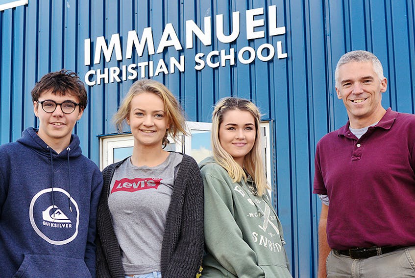 Immanuel Christian School students, from left, Ben Keizer, Hope Sider and Annabelle Orichefsky chat with vice-principal and high school teacher Rob MacDonald earlier this week. The school will open its doors to the community during the Harvest Festival from 11 a.m. to 2 p.m. on Saturday.  ©THE GUARDIAN/Mitch MacDonald