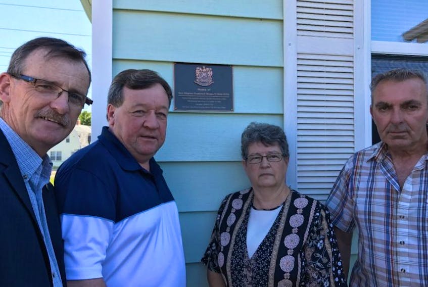 Submitted-----Charlottetown Mayor Clifford Lee, second from left, and Coun. Terry MacLeod, left, present a plaque of recognition with current homeowners, Melvin and Debbie Ramsay, to acknowledge the home formerly owned by Don Messer.